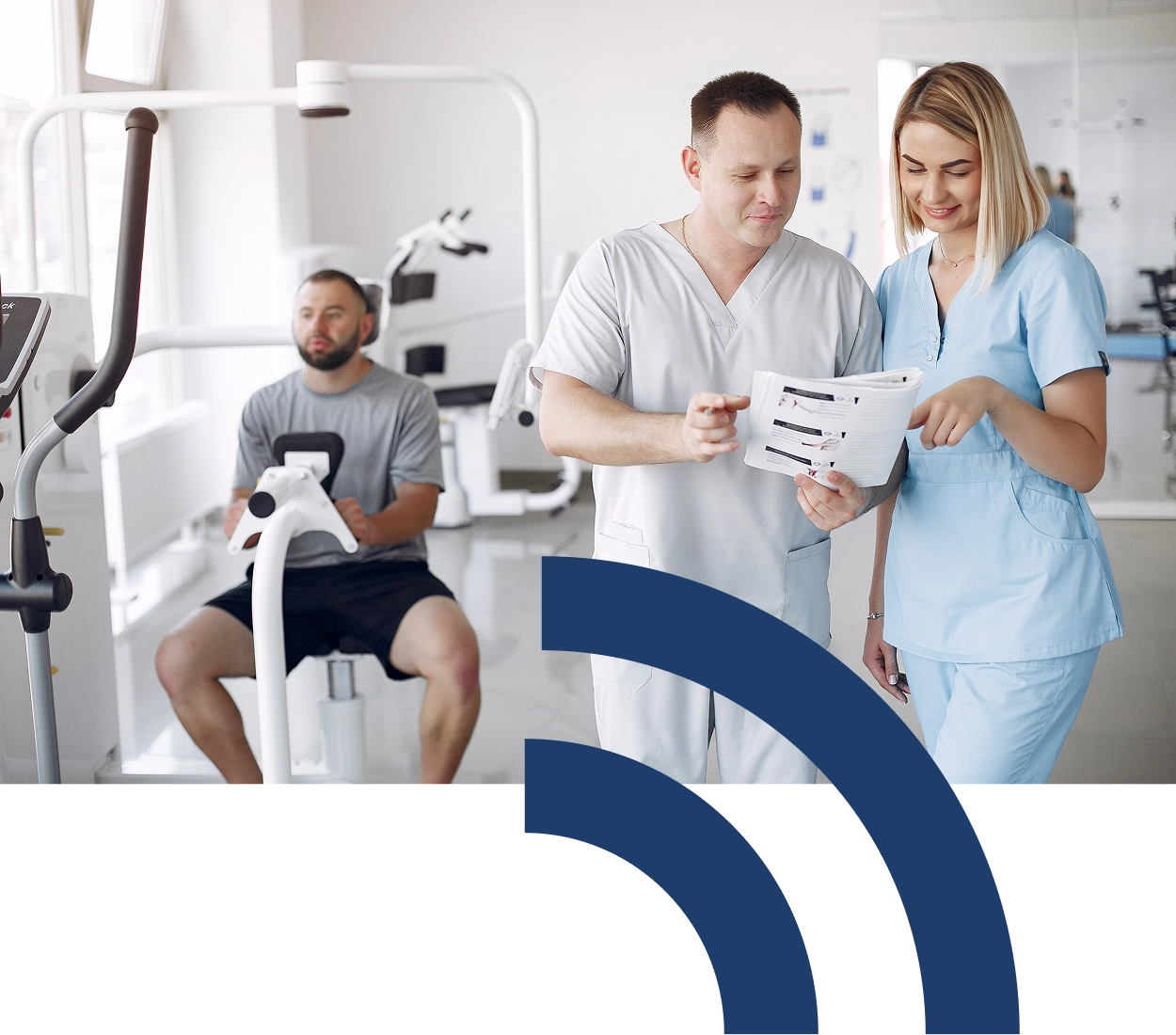 Dva zdravotní pracovníci konzultují plán péče s pacientem v rehabilitačním centru.