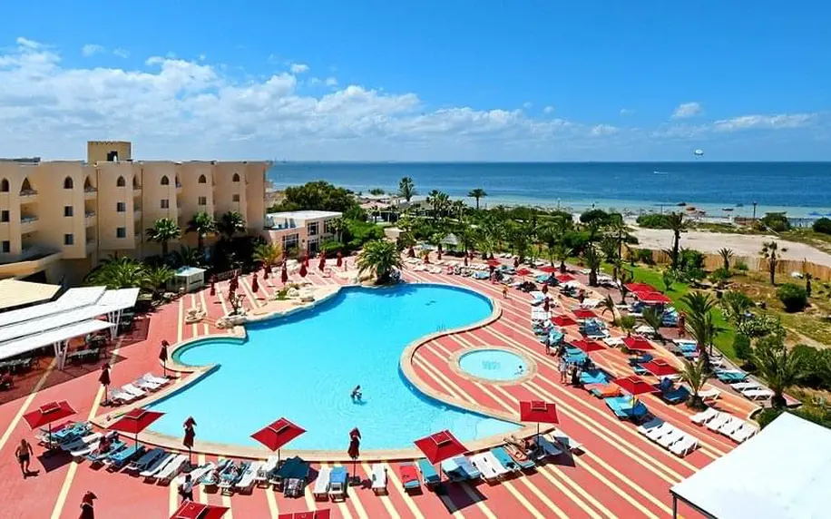 Velký bazén v tuniském hotelu s výhledem na moře.