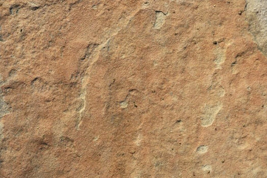 Detail pískovcové skály s viditelnou strukturou zrn.